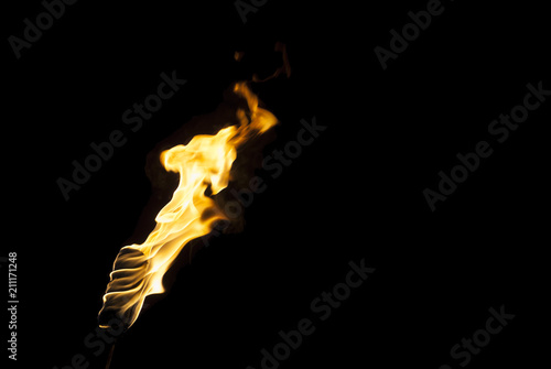 Photos flame of a torch in the dark on a black background, only the fire is visible