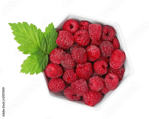 Bowl with ripe raspberries on white background, top view
