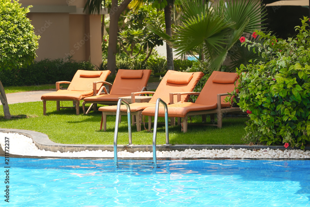 Sunbeds near modern swimming pool at resort