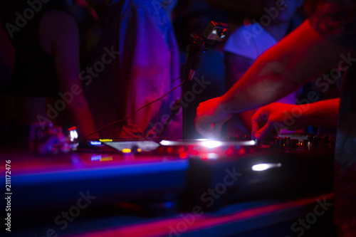 DJ tocando con tornamesas en discoteca