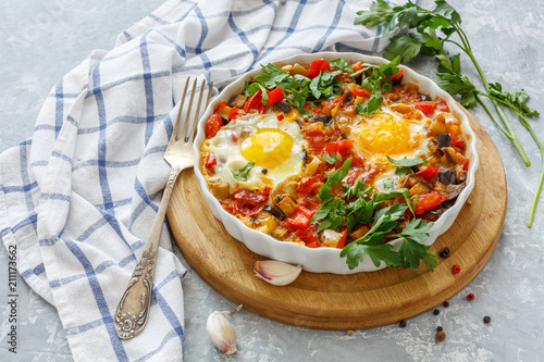 Spicy shakshuka with eggs, eggplant and tomatoes.