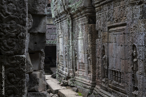 Ancient stone ruin in Angkor Wat temple. Carved stone bas-relief gallery. Khmer kingdom heritage ruin in jungle.