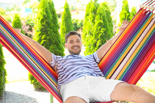 Man relaxing in hammock outdoors on warm summer day