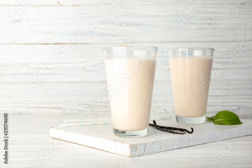 Glasses with vanilla milk shakes on table