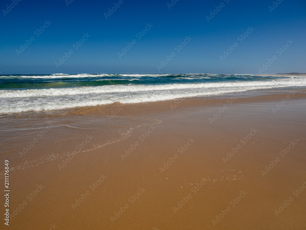 Beautiful empty paradise beach at the ocean with turquoise water, waves and yellow sand Beautiful empty paradise beach at the ocean with turquoise water, waves and yellow sand