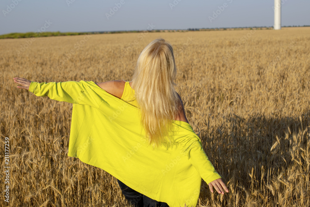 Happy life style. A girl in the field. The girl in the field of wheat is running. Freedom as a life style.