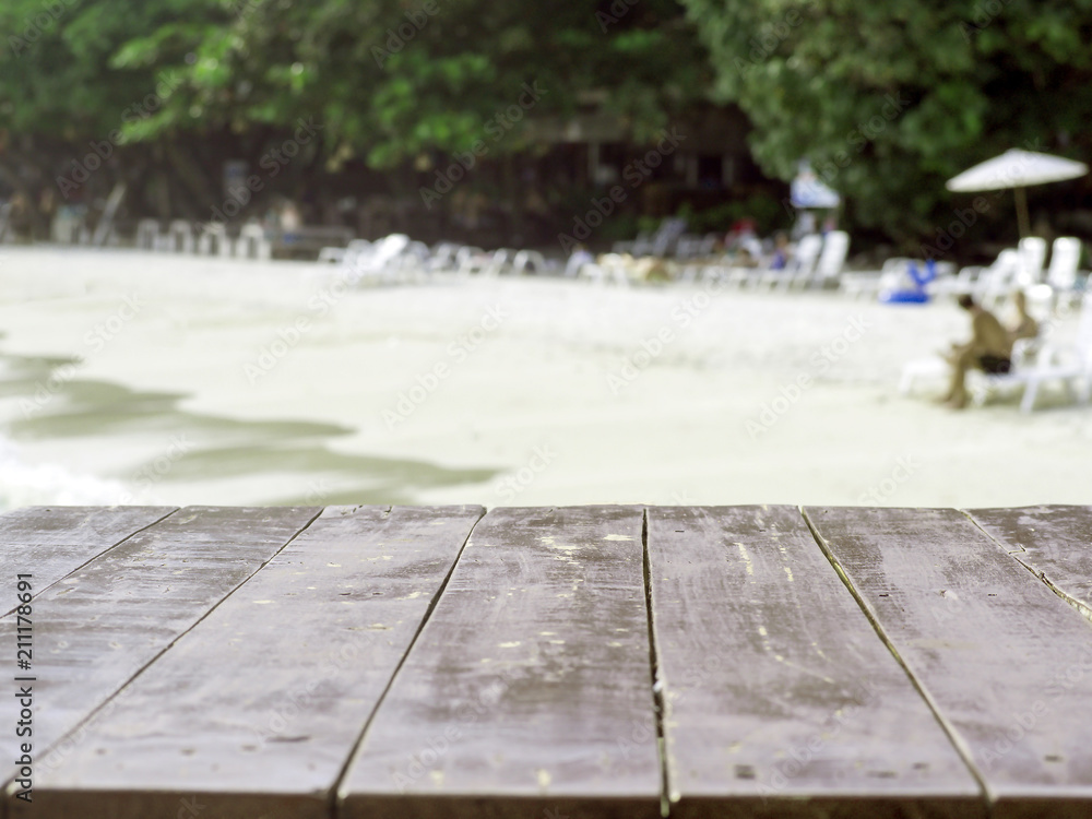 The blur cool sea background with wood floor foreground on horizon tropical sandy beach; relaxing outdoors vacation with heavenly mind view at a resort deck touching sunshine