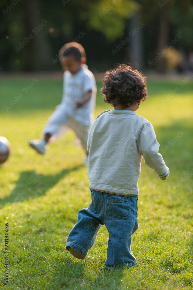 Obraz premium Little boy watchen kid playing with soccer ball