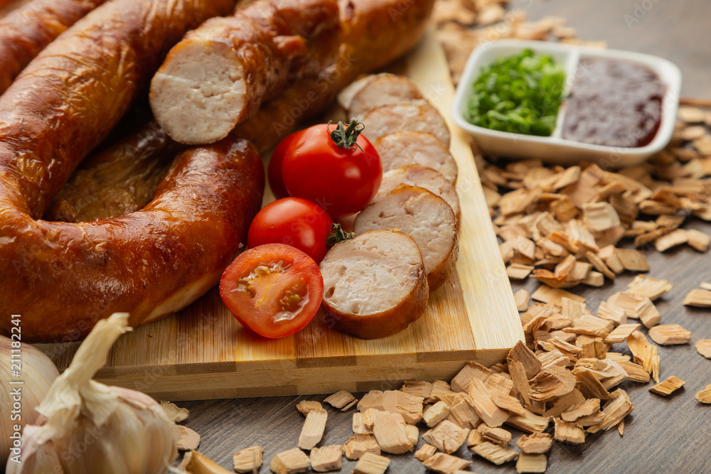 Homemade sausage on a wooden background with seasonings and sauce. Homemade sausage on a wooden background with seasonings and sauce.