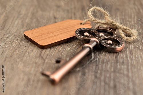 Decorative metal key on a wooden background stock images. Decorated key images. Romantic key with wooden label. Key on the table