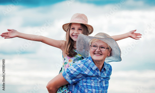 Childhood. Happy little girl and her grandmother enjoys together in a good mood. Family, lifestyle concept