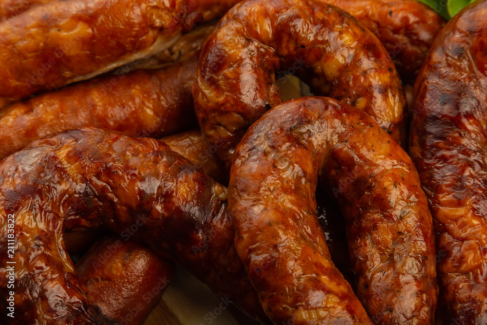 Homemade sausage on a wooden background with seasonings and sauce. Homemade sausage on a wooden background with seasonings and sauce.
