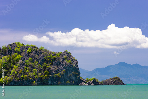 Rocky small island in sea near by tropical beach on Langkawi