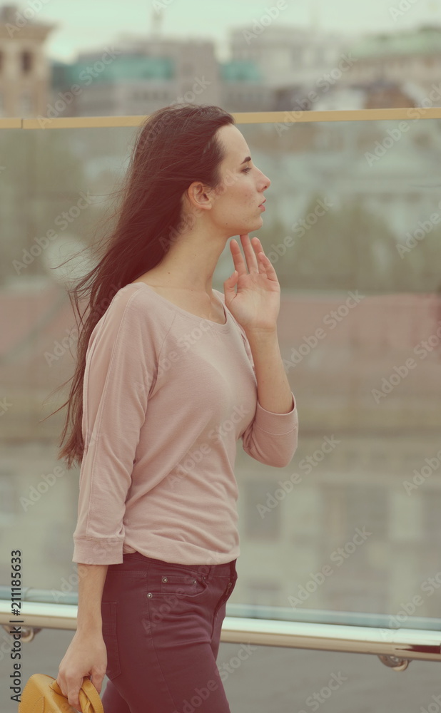 Fototapeta premium Pretty young woman posing near a glass wall
