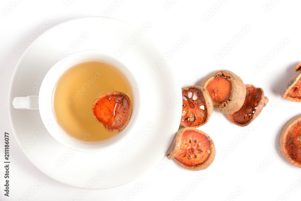 Slices of dry bael fruit and cup of dried bael juice on white background. (Aegle marmelos) Slices of dry bael fruit and cup of dried bael juice on white background. (Aegle marmelos)