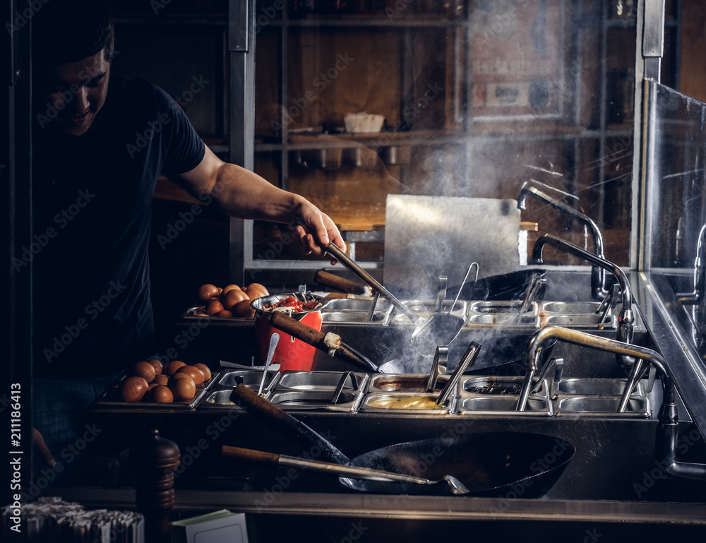 Cooking process in an Asian restaurant. Cook is stirring vegetables in wok. Cooking process in an Asian restaurant. Cook is stirring vegetables in wok.