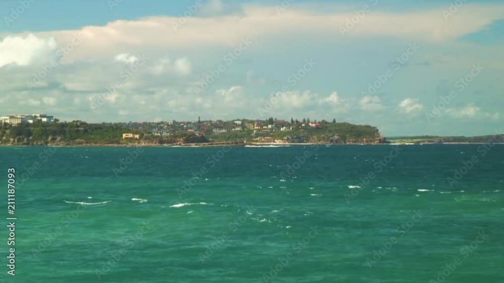 Zoom-out of Rocky Beach and a Town in the Distance Zoom-out of Rocky Beach and a Town in the Distance