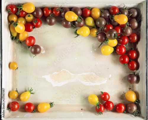 Fresh yellow, red and brown tomatoes from the market in a vintage tray, can be used as background