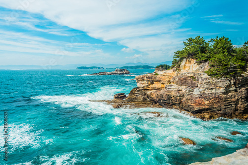 Landscape of the sea with rocks in the foreground and islands and blue sky in the background. photo