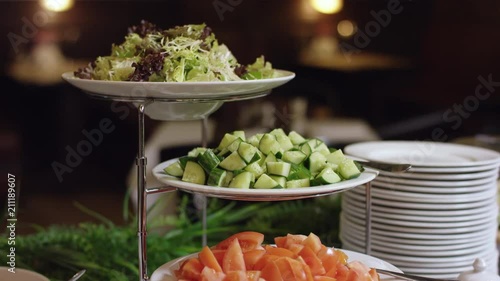 Lettuce leaves and sliced cucumbers and tomatoes beautifully served on a banquet table