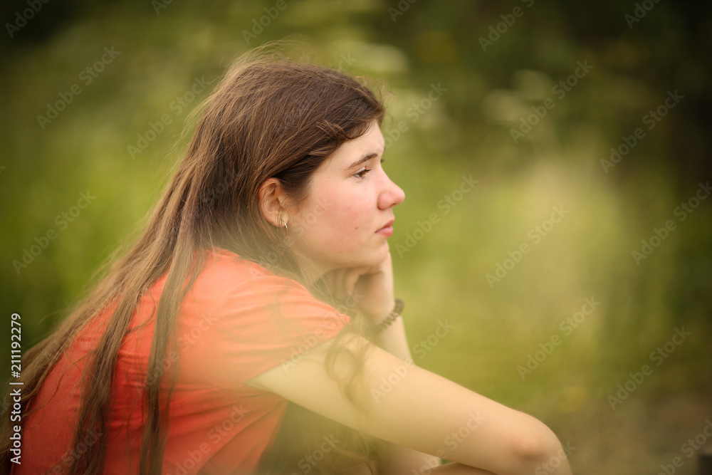 teenager girl with long thick brown hair outdoor portrait on green summer field background teenager girl with long thick brown hair outdoor portrait on green summer field background