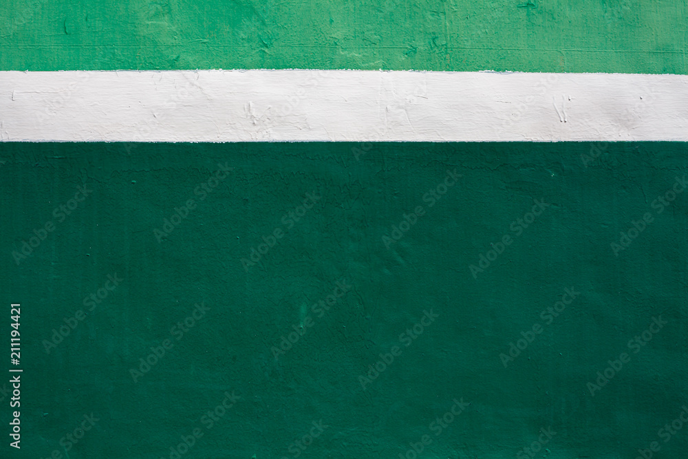 Fototapeta premium White stripe on green background. Paint smudges on the surface. Painted metal surface. Metal painted in white and green. Space for your text on deformed ..painted metal.
