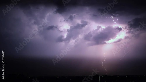 Night stormy sky above city. Set of beautiful lightning strikes. Thunderstorm clouds. Timelapse. Slow motion. photo