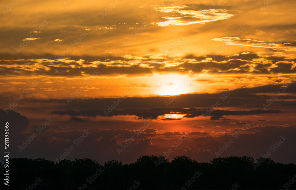 Sunrise with sun peeping through clouds