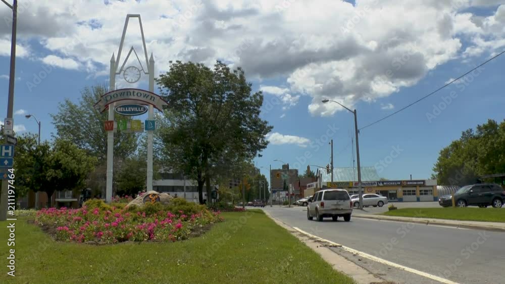 Downtown gateway sign with flowers and cars driving by Downtown gateway sign with flowers and cars driving by