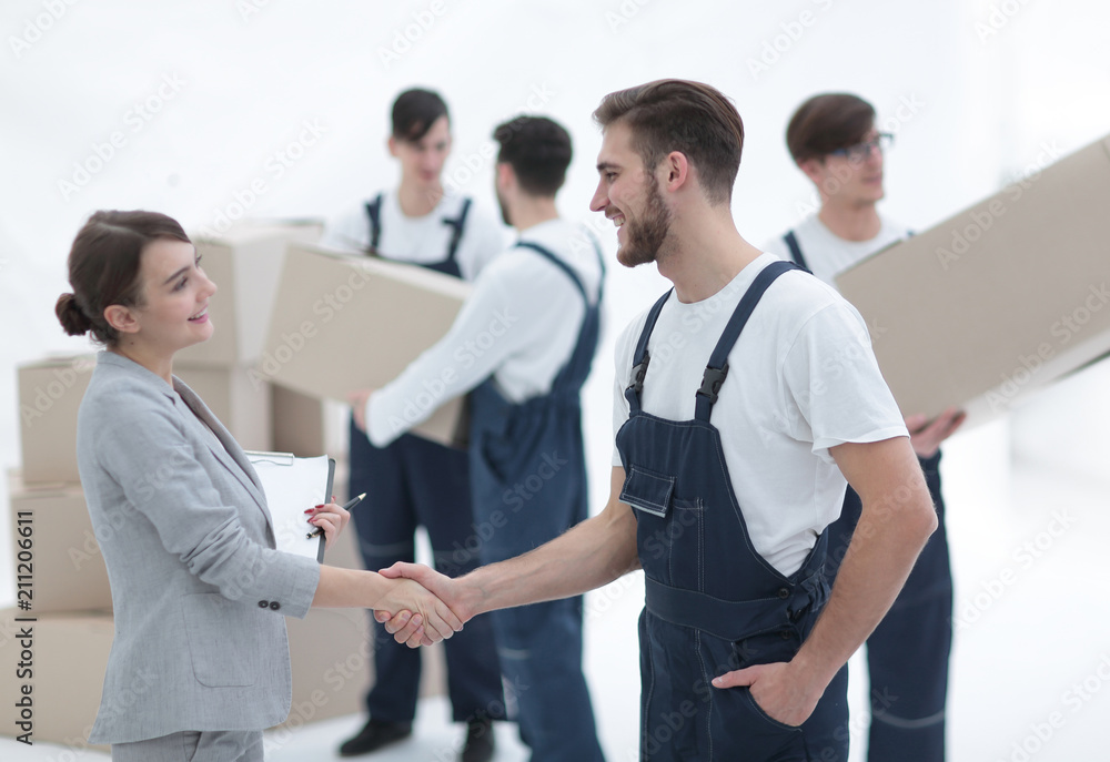 Manager with clipboard shaking hands with movers. Manager with clipboard shaking hands with movers.