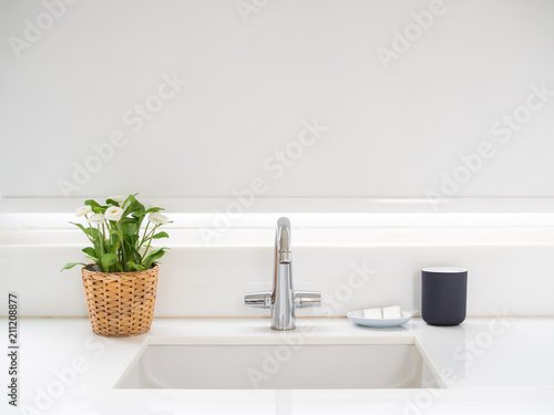 фотографія Clean White Bathroom Interior with Sink Basin Faucet, Flower in Weave Pot, Soap and Ceramic Mug
