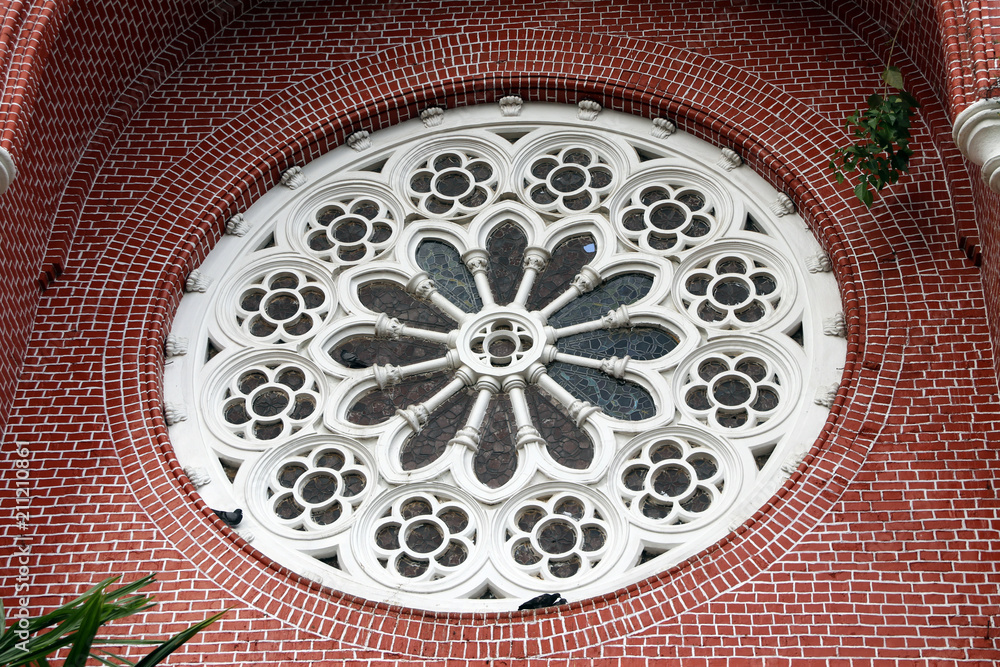 White Circle Mortar flower pattern with Stained Glass and red brick of exterior of church gable at cathedral of the holy trinity, the church of the province of Myanmar.