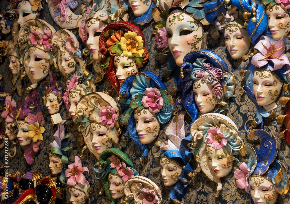 Small souvenir Venetian masks for sale on the streets of Venice, Italy. Masks are decorated with ragged headgear.