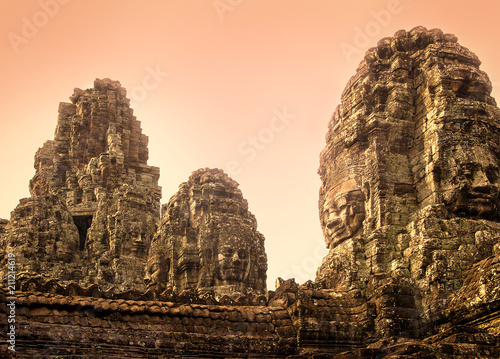 Stone statues of smiling Buddhas in the complex of Angkor Thom, Siem Reap, Cambodia at sunrise