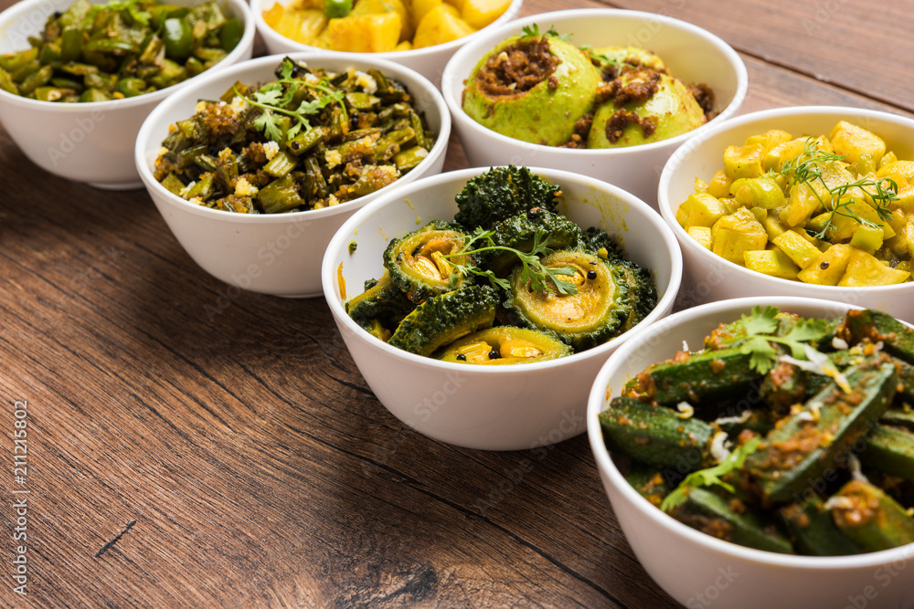 Indian sabzi / vegetable fried recipes served in white bowl over moody or colourful background. selective focus Indian sabzi / vegetable fried recipes served in white bowl over moody or colourful background. selective focus
