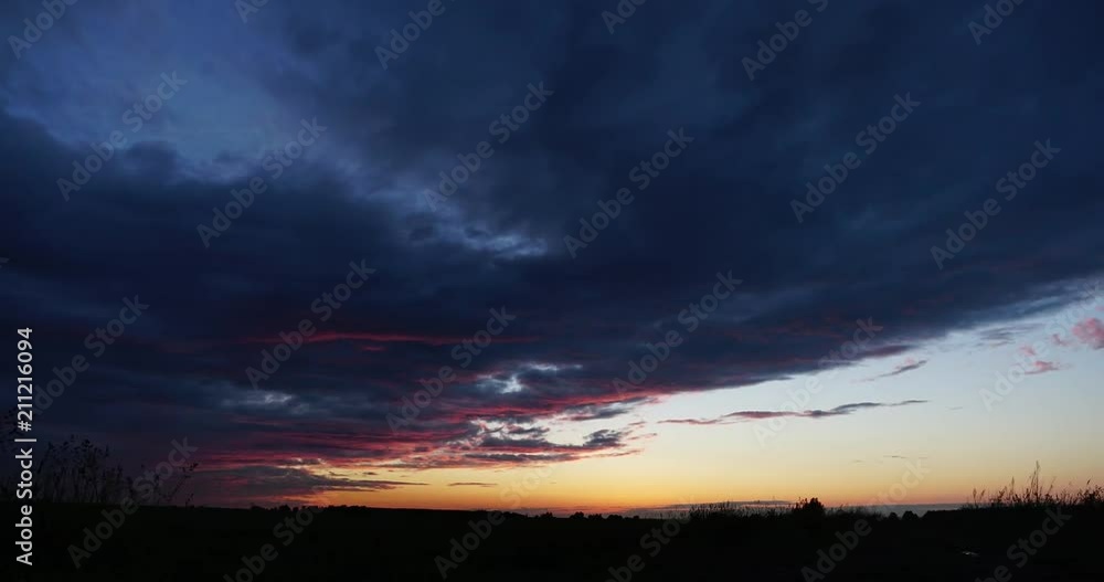 Time Lapse. Field At Evening Sunset. Natural Bright Dramatic Sky Pink Colours Above Countryside Landscape Time Lapse. Field At Evening Sunset. Natural Bright Dramatic Sky Pink Colours Above Countryside Landscape
