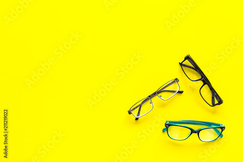 Glasses concept. Set of glasses with different eyeglass frame and transparent lenses on yellow background top view copy space