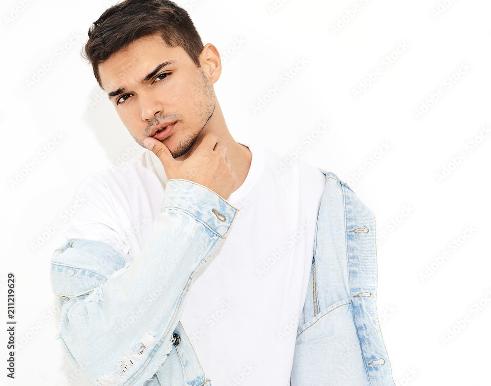 Portrait of handsome young model man dressed in jeans clothes posing on white background. Isolated Portrait of handsome young model man dressed in jeans clothes posing on white background. Isolated