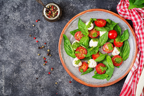 Caprese salad. Healthy meal with cherry tomatoes, mozzarella balls and basil. Home made, tasty food. Concept for a tasty and healthy vegetarian meal. Top view. Flat lay