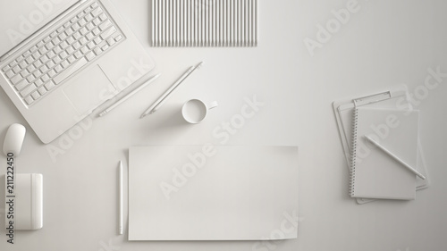 White monochrome minimal office table desk. Workspace with laptop, notebook, pencils and coffee cup. Flat lay, top view, blank paper mockup template