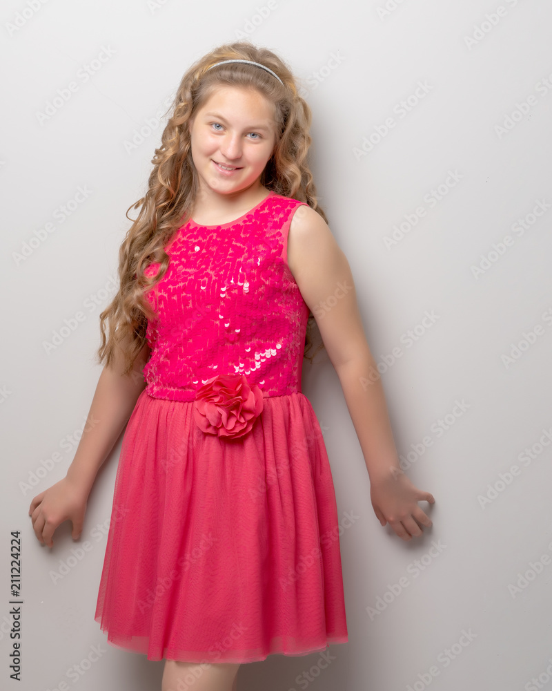 A little girl with long silky hair near the wall. A little girl with long silky hair near the wall.