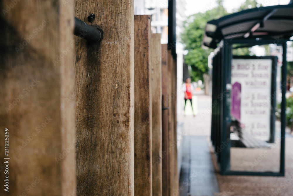 urban street scene, fence, bus shelter and person walking urban street scene, fence, bus shelter and person walking