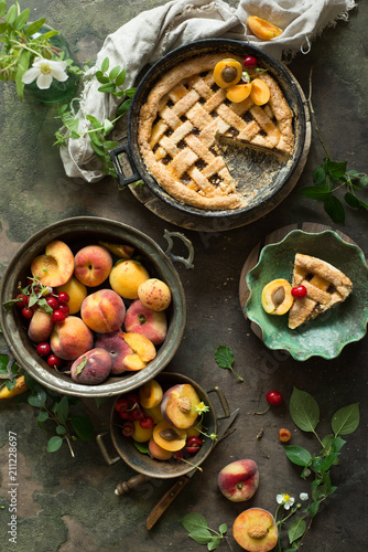 Fruit pie on colorful wooden rustic background with fresh peaches