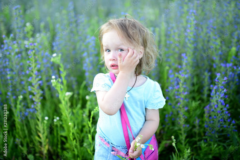 Charming little girl stands on the field full of lavander Charming little girl stands on the field full of lavander