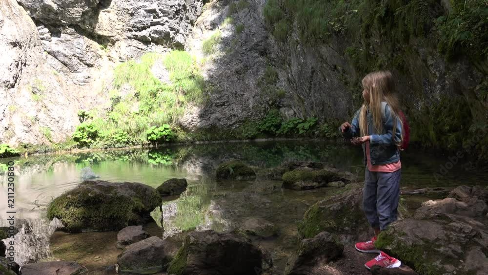 Child Playing by a Mountain River Throwing Pebbles in Water, Kid in Mountains, Girl Relaxing Outdoor Child Playing by a Mountain River Throwing Pebbles in Water, Kid in Mountains, Girl Relaxing Outdoor