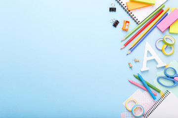 Colorful stationary school supplies on blue trending background, space or text flat lay