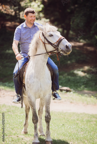 The elegance boy riding on horse along park