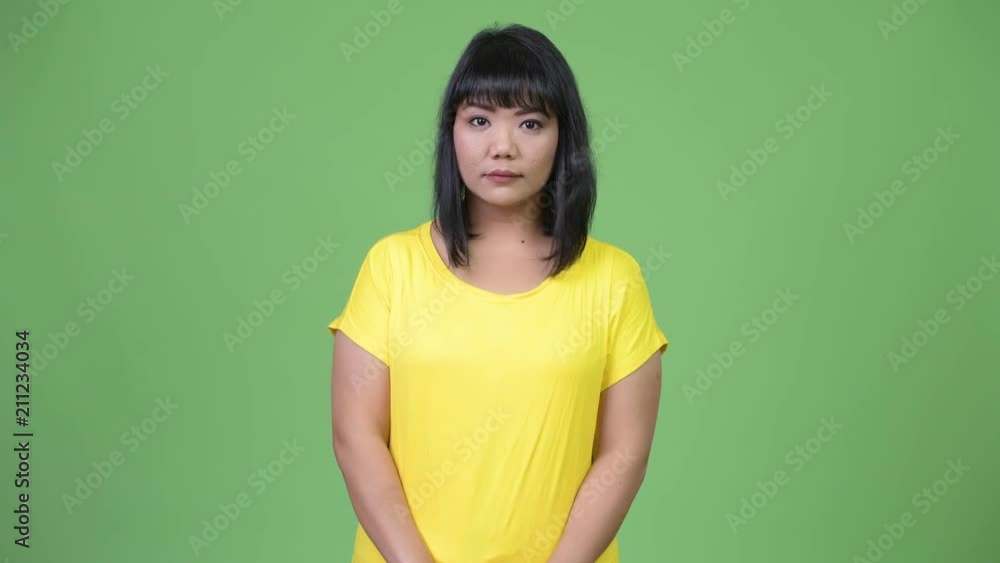 Beautiful Asian woman against green background Beautiful Asian woman against green background