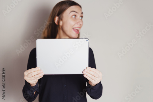 Beautiful blonde smiley woman holding tablet photo