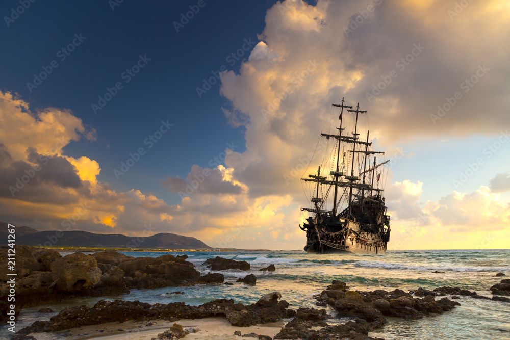 Obraz premium Statek piracki na otwartym morzu o zachodzie słońca
